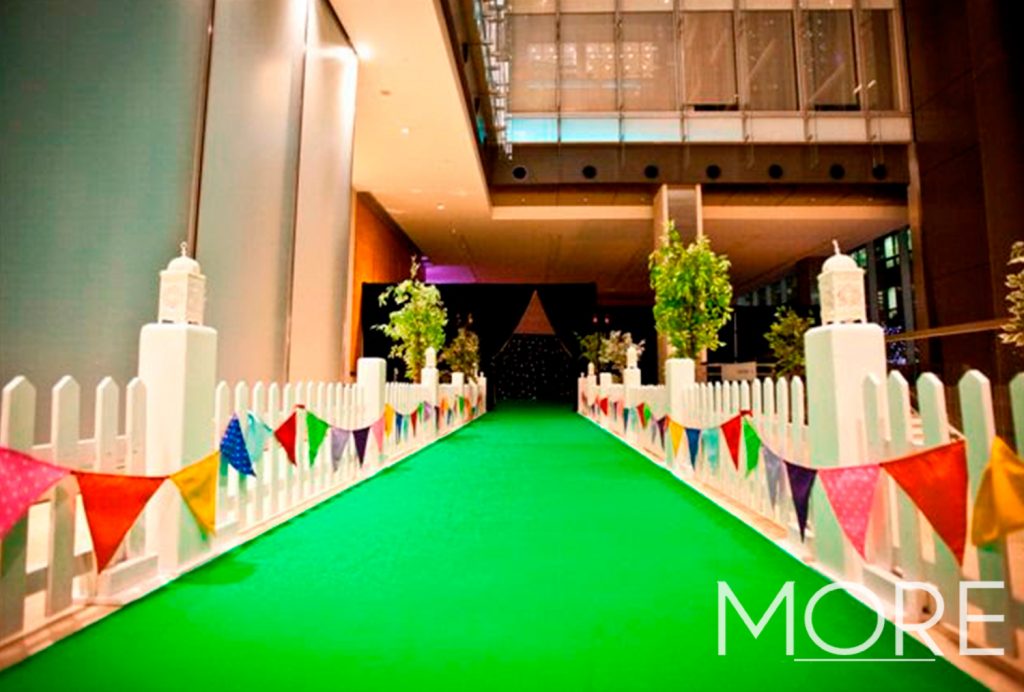 Event green carpet walkway with white picket fencing